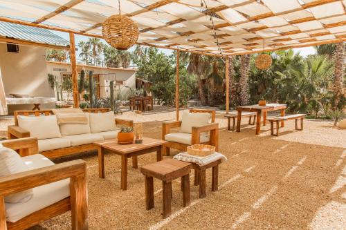 an outdoor patio with wooden furniture and tables at Cien Palmas- Authentic Mexican Casita 1 -Downtown in Todos Santos