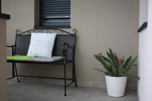 a black chair with a pillow and a plant at Pia´s Bleibe in Caldaro