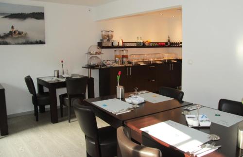 a restaurant with two tables and chairs and a kitchen at Hotel am Markt in Cochem