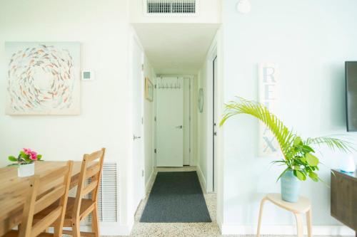 a hallway with a table and a potted plant at Casa Limonada Boutique Motel in Sarasota