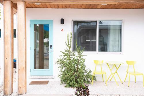 a white house with a blue door and chairs at Casa Limonada Boutique Motel in Sarasota