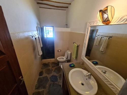 uma casa de banho com um lavatório, um WC e um espelho. em Luxury boutique villa with gorgeous pool em Malindi