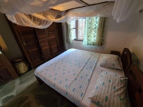 um quarto com uma cama grande e uma janela em Luxury boutique villa with gorgeous pool em Malindi
