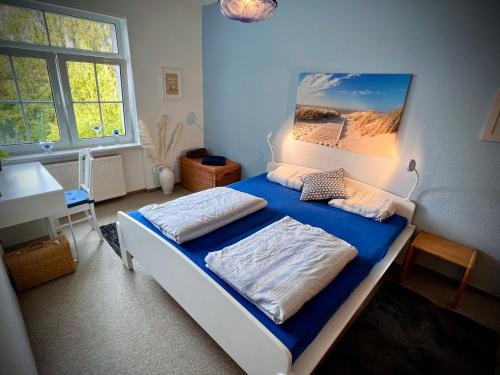 - une chambre dotée d'un lit avec des draps bleus et un tableau dans l'établissement Ferienwohnung Rostock Nähe Warnemünde, à Rostock