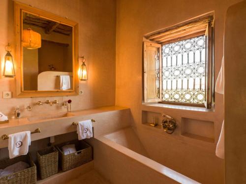 a bathroom with a tub and a sink and a window at CASA ABRACADABRA in Marrakech