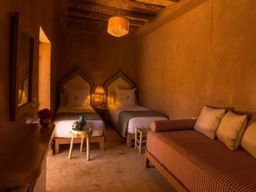 a room with two beds and a couch and a table at CASA ABRACADABRA in Marrakech