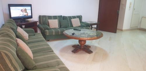 a living room with a couch and a coffee table at Le Palace Clinique Jasmin Carthgene Pasteur in Tunis