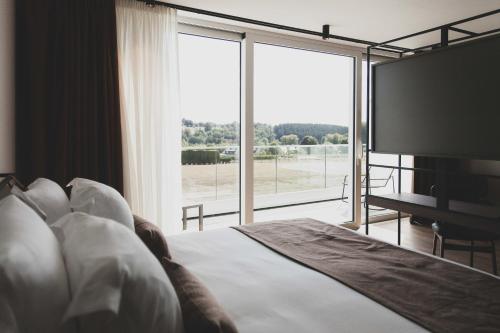 a bedroom with a large bed and a large window at Roannay - Francorchamps in Francorchamps