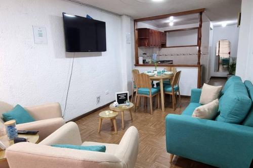 a living room with couches and a table and a kitchen at Hermosos apartamentos en Funza in Funza