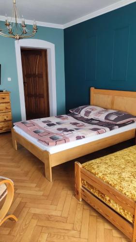 a bedroom with two beds and a blue wall at Dom Sula in Ustrzyki Dolne