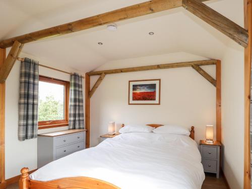a bedroom with a white bed and a window at Meikle Conval in Keith
