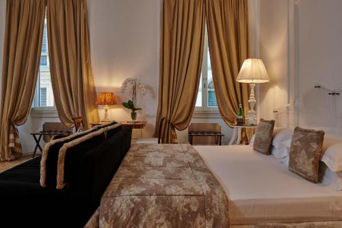 a hotel room with a bed and a couch at Casa Howard Firenze - Residenza d'Epoca in Florence