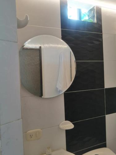 a bathroom with a mirror and a toilet at Greenhouse- Apartamentos in Bucaramanga