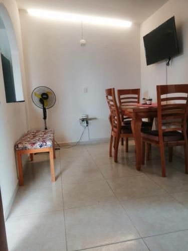 a dining room with a table and chairs and a television at Greenhouse- Apartamentos in Bucaramanga