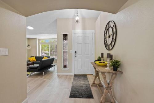a living room with a table and a clock on the wall at Remodeled, Charming Retreat on the City's Doorstep in Boise