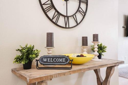 a welcome sign on a wooden table with a clock on the wall at Remodeled, Charming Retreat on the City's Doorstep in Boise