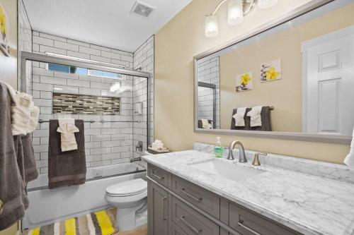 a bathroom with a sink and a toilet and a mirror at Remodeled, Charming Retreat on the City's Doorstep in Boise