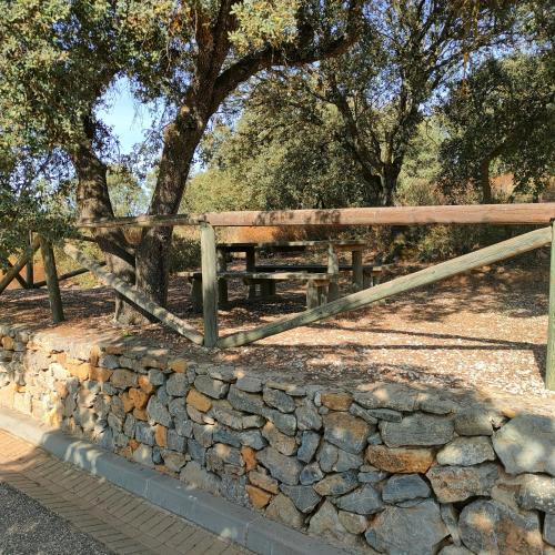 a wooden bench sitting next to a stone wall at Hotel Rural Carlos Astorga in Archidona