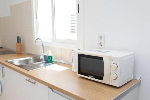 un bancone della cucina con forno a microonde e lavandino di White House ad Arrecife