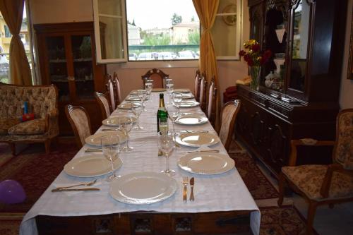 a long table with white plates and wine glasses at Private Villa AKOBARA, 2km from city center in Corfu Town