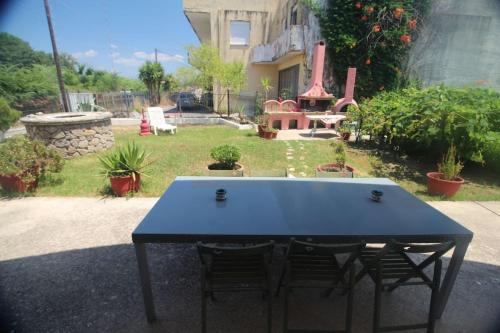 a blue table with two chairs in a yard at Private Villa AKOBARA, 2km from city center in Corfu Town