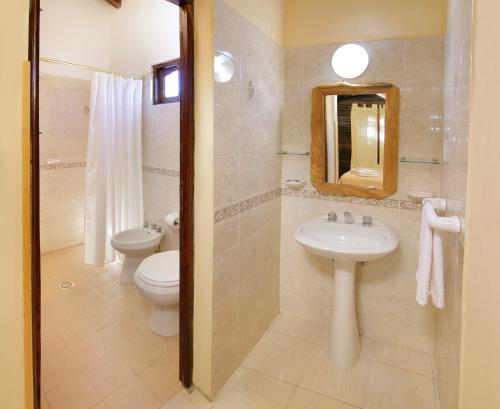 a bathroom with a sink and a toilet and a mirror at Posada Pfullendorf - Adults Only in Villa General Belgrano