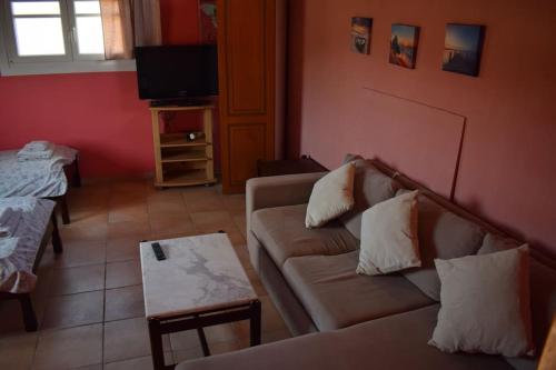 a living room with a couch and a tv at Private Villa AKOBARA, 2km from city center in Corfu Town