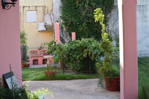 a garden with a red bench and some plants at Private Villa AKOBARA, 2km from city center in Corfu Town