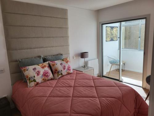 ein Schlafzimmer mit einem großen Bett und einem Balkon in der Unterkunft Apartamento Cinema para férias em Esposende in Esposende