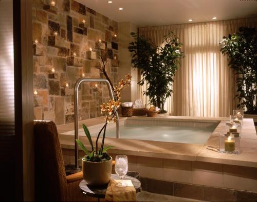 a bathroom with a tub with plants and a table at Mokara Hotel & Spa in San Antonio