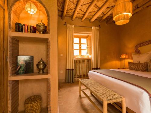 a bedroom with a bed and a bench in a room at CASA ABRACADABRA in Marrakech