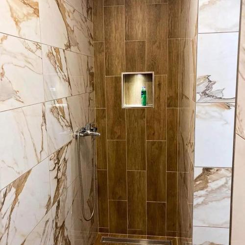 La salle de bains est pourvue d'une douche avec une porte en verre. dans l'établissement Kosmajski raj, à Nemenikuće