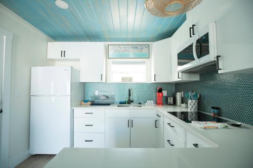 a kitchen with white cabinets and a blue ceiling at Casa Limonada Boutique Motel in Sarasota