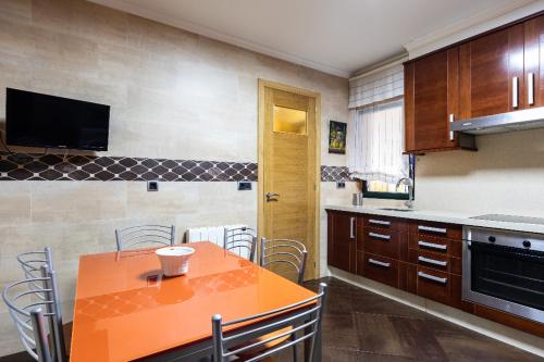een keuken met een oranje tafel en stoelen bij piso vacacional en la playa de Rodeira in Cangas de Morrazo