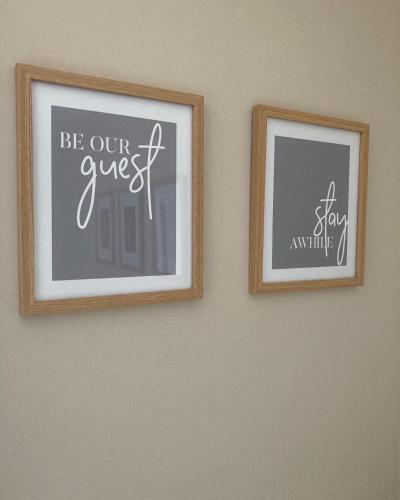 two framed pictures on a wall with writing on it at Loanside Lodge, Self-Catering, Holm, Orkney. in Saint Marys