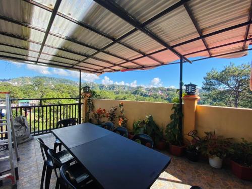 a patio with a table and chairs on a balcony at Bilman's Transient House in Baguio