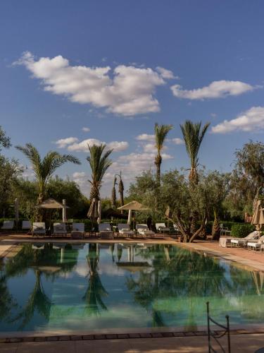 a large swimming pool with palm trees in the background at CASA ABRACADABRA in Marrakech