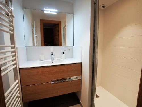 une salle de bain avec un lavabo et un miroir dans l'établissement Appartement lumineux avec terrasse, proche pistes et commodités, Les Gets - FR-1-598-93, aux Gets