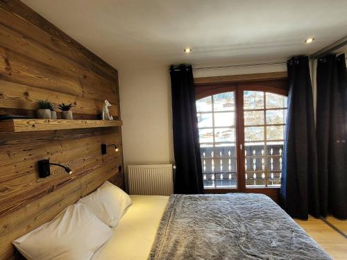 une chambre avec un lit et une grande fenêtre dans l'établissement Appartement rénové 2 chambres - 5 pers, balcon, parking, WIFI Les Gets - FR-1-598-98, aux Gets