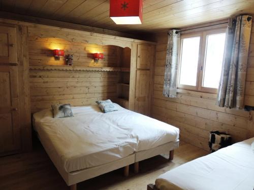 um quarto com 2 camas num chalé de madeira em Appartement Les Gets, 3 pièces, 6 personnes - FR-1-598-83 em Les Gets