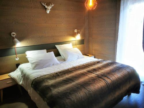 une chambre avec un lit avec une couverture dessus dans l'établissement Beau T2 classé 3*, centre Les Gets, terrasse, parking, locaux à skis et vélos - FR-1-598-88, aux Gets