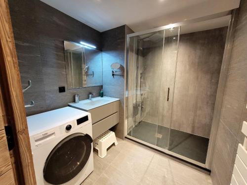 La salle de bains est pourvue d'un lave-linge et d'une douche. dans l'établissement Beau T2 classé 3*, centre Les Gets, terrasse, parking, locaux à skis et vélos - FR-1-598-88, aux Gets