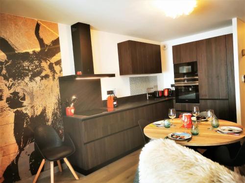une cuisine avec une table et une salle à manger dans l'établissement Beau T2 classé 3*, centre Les Gets, terrasse, parking, locaux à skis et vélos - FR-1-598-88, aux Gets