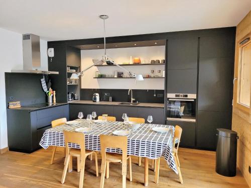 une cuisine et une salle à manger avec une table et des chaises dans l'établissement Appart charmant avec Jacuzzi, Terrasse, Parking & WiFi - FR-1-598-92, aux Gets