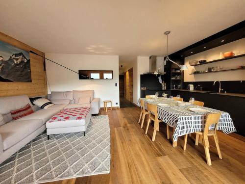 un salon avec un canapé, une table et des chaises dans l'établissement Appart charmant avec Jacuzzi, Terrasse, Parking & WiFi - FR-1-598-92, aux Gets
