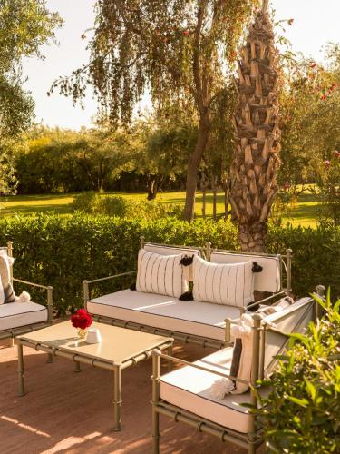 a patio with benches and tables in a park at CASA ABRACADABRA in Marrakech