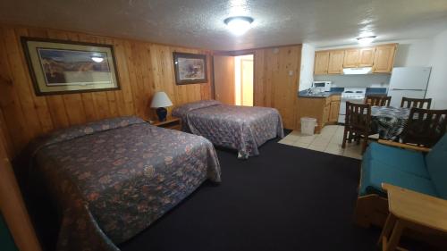 Una habitación de hotel con dos camas y cocina. en Westwood Motel, en West Yellowstone