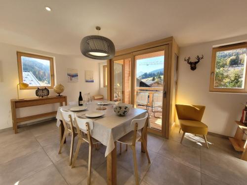 une salle à manger avec une table, des chaises et des fenêtres dans l'établissement Appartement lumineux et spacieux avec 2 terrasses, proche des pistes et commerces aux Gets - FR-1-598-94, aux Gets