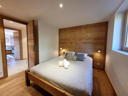 - une chambre avec un lit et un mur en bois dans l'établissement Appartement lumineux et spacieux avec 2 terrasses, proche des pistes et commerces aux Gets - FR-1-598-94, aux Gets
