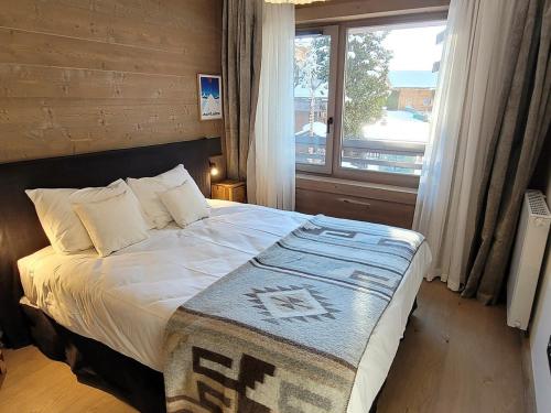 een slaapkamer met een groot bed en een raam bij Appartement Les Gets, 5 pièces, 8 personnes - FR-1-598-99 in Les Gets